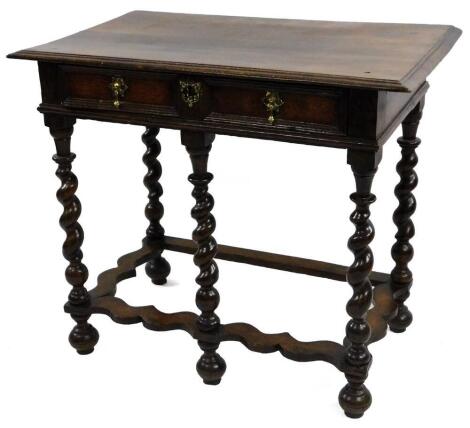 A late 17thC/early 18thC oak side table, the rectangular top with a moulded edge above a panelled frieze drawer with brass tear drop shaped handles and butterfly escutcheon, on spirally turned supports with wavy stretcher and bun feet, 76cm H, 91cm W, 53c