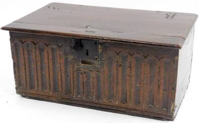 A late 16thC/early 17thC oak bible box, the rectangular top with a moulded edge, the base carved with flutes and iron lock plate and strap, 24cm H, 54cm W, 32cm D.