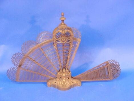 A pierced brass fan fireguard of rococo design