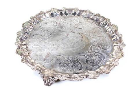 A George IV silver salver, of pie crust form with a scroll and shell border, partially chased with further scrolls to the centre, on triple pierced scroll feet, London 1828, 37cm W, 38½oz.