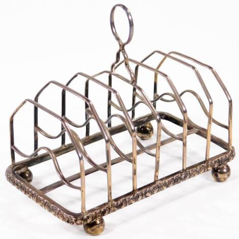 A 19thC silver seven bar toast rack, with plain slender loop handle and raised upon four compressed ball feet, indistinct marks, 7oz.