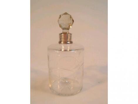 A cut glass cylindrical scent bottle with facet cut stopper and silver mounted neck