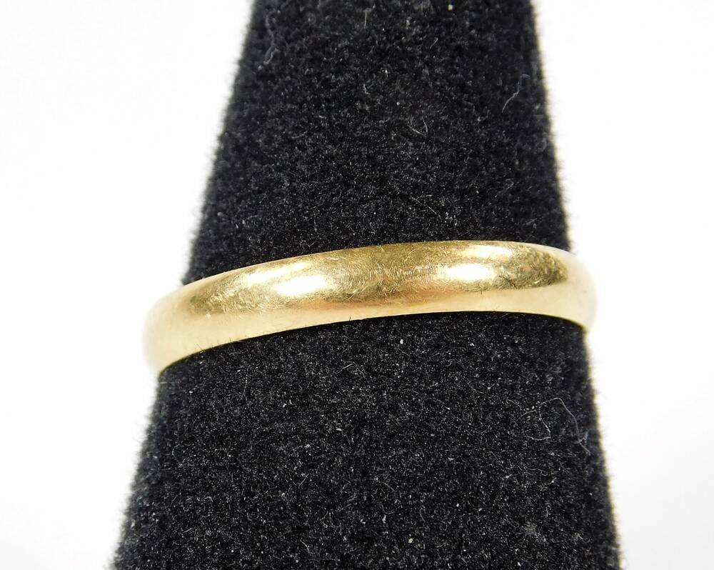 A 18ct gold plain wedding band with maker s stamp PHW London