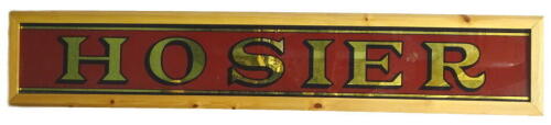 An early to mid 20thC Hosier shop sign, with verre eglomise letters, in later frame, 31cm, 174cm W. Provenance: Formerly at the shop of Lawrence Clarke, a Lincoln tailor from 1950 to late 1990's. His shop at 43 Silver Street was started by his father aft