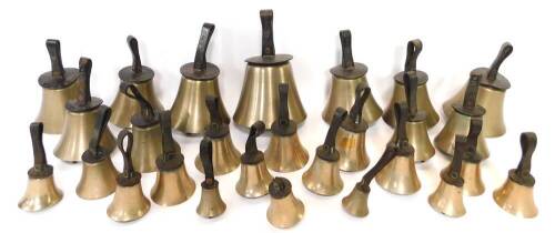 Twenty seven hand bells by J Shaw Son & Company, Leeds Road, Bradford., many with internal hammers, with leather handles indicating the music note.