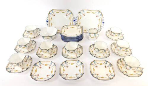 An early 20thC Shelley porcelain part tea service, decorated with swags of fruit, no.11705D, printed and painted marks, comprising pair of bread plates, cream jug, sugar bowl, nine tea cups, twelve saucers and eleven tea plates.