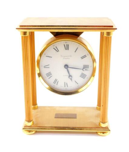 A Garrard and Company late 20thC gold plated brass mantel clock, of portico form, with fluted columns, circular dial bearing Roman numerals, Swiss Quartz movement, boxed, with insurance certificate and associated paperwork, 18cm H, 14.5cm W.