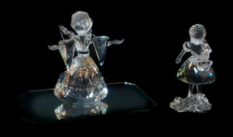 A Swarovski Crystal Christmas angel, boxed, and Girl with basket, boxed. (2)