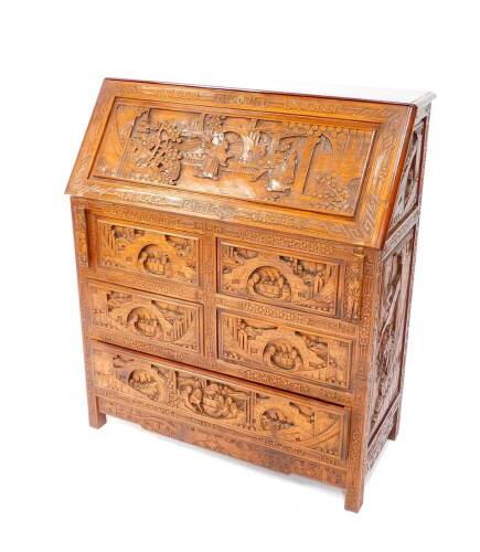 A Chinese hardwood bureau, profusely carved with buildings, trees and figures, the fall flap opening to reveal a central drawer and recesses, over four short and one long drawer, raised on square legs, 107cm H, 91cm W, 41.5cm D.