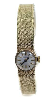 A Longines lady's 9ct gold cased wristwatch, circular champagne dial, with gold batons, on a 9ct gold mesh strap with snap clasp, 21.1g all in.