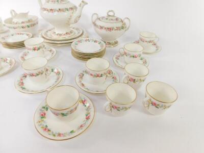 A mid 19thC Ridgways porcelain tea service, decorated with a band of roses, comprising teapot on stand, slop bowl, sucrier, cream jug, a pair of bread plates, sixteen cups, twelve saucers and tea plates. - 2