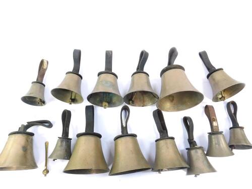 Fourteen hand bells by W Pawson, Leeds, some with hammers, with leather handles, bearing labels from Biggleswade.