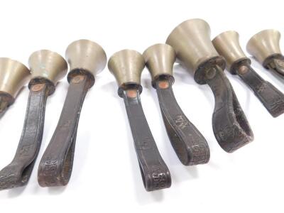 Twelve small hand bells by J Shaw Son & Company, Bradford, all with hammers, tooled leather handles. - 4