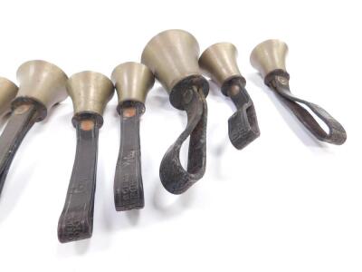 Twelve small hand bells by J Shaw Son & Company, Bradford, all with hammers, tooled leather handles. - 5