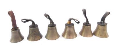 Six hand bells, hammers lacking, with tooled leather handles.