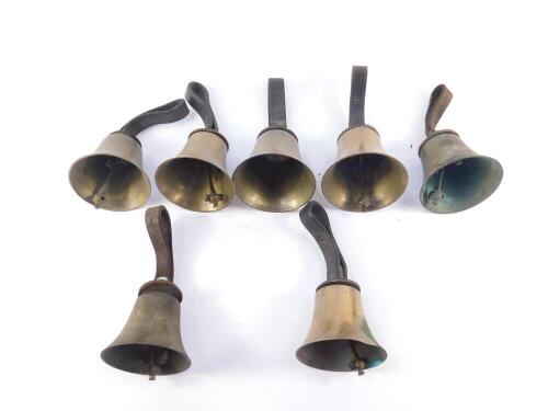 Seven hand bells, with hammers, one lacking, tooled leather handles.