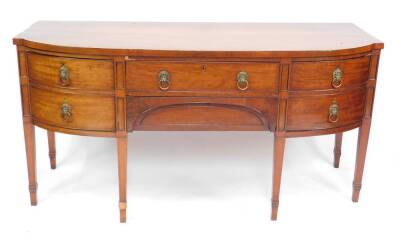 A George III mahogany bow front sideboard, with line inlay, and brass lion head and ring handles, having one long over one cushion drawer, flanked by two doors, one holding a cellarette, raised on tapering square legs and collared feet, 191cm H, 82cm W,