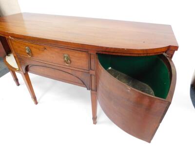 A George III mahogany bow front sideboard, with line inlay, and brass lion head and ring handles, having one long over one cushion drawer, flanked by two doors, one holding a cellarette, raised on tapering square legs and collared feet, 191cm H, 82cm W, - 3