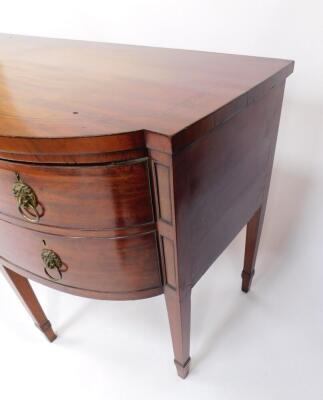 A George III mahogany bow front sideboard, with line inlay, and brass lion head and ring handles, having one long over one cushion drawer, flanked by two doors, one holding a cellarette, raised on tapering square legs and collared feet, 191cm H, 82cm W, - 5