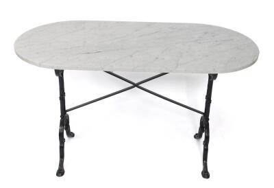 An oval white marble and cast iron table, raised on a shaped supports united by an X frame stretcher, 72cm H, 119cm W, 60cm D.