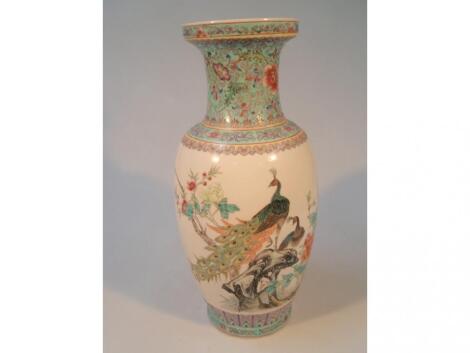 A Chinese baluster vase hand painted in polychrome enamels with peacocks