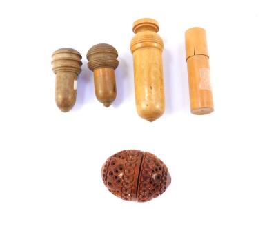 Four treen needle cases, together with a couquilla nut thimble case. (5)