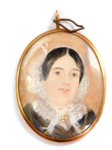 A Victorian portrait miniature of a lady, in an oval gilt metal mount, verso centred with crossed hair, within a cobalt blue guilloche enamel border, 56mm x 44mm.