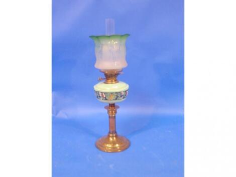 A Victorian oil lamp, with an opaque green glass reservoir, decorated with