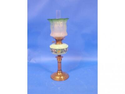 A Victorian oil lamp, with an opaque green glass reservoir, decorated with