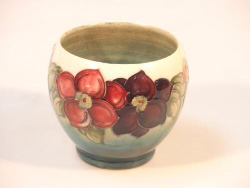 A Moorcroft ovoid vase with anemone decoration in red and purple on a shaded blue ground