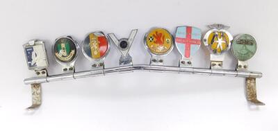 Lincolnshire related car badges, to include Lincolnshire Vintage Vehicle Society, Ruston Auto Club Lincoln, AA Badge 6028871, Scotland Car Badge, Veteran Motorcyclist's VN34, etc., on a chromed metal rail. (8)
