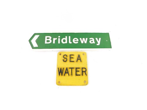 A painted cast aluminium sign, with lettering in relief inscribed Sea Water, 20cm x 18cm, and a cast aluminium Bridleway sign by The Royal Label Factory, 55cm x 14cm. (2)