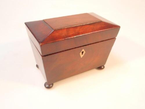 A Victorian flamed mahogany sarcophagus tea caddy on bun feet