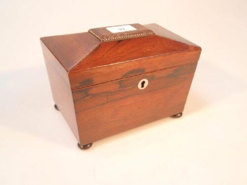 A Victorian rosewood sarcophagus tea caddy on bun feet