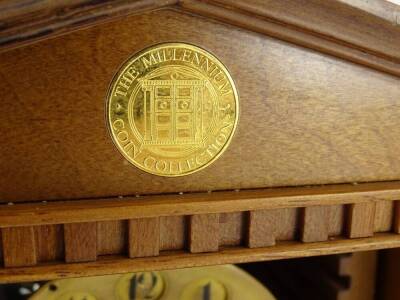 An unusual clock and weather station, housed in a cabinet previously containing the Millennium coin collection, the interior fitted with a clock, barometer and thermometer etc., 33cm W. - 2