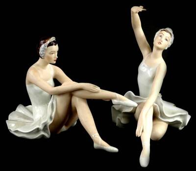 A pair of Royal Dux porcelain figurines, each modelled in the form of a seated ballet dancer, 23cm W.