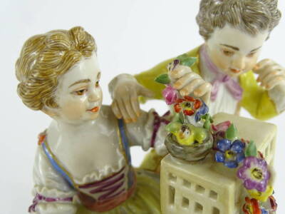 A late Meissen porcelain figure group, comprising a young boy and a girl beside a rectangular cage, holding garlands of flowers etc., on an oval base, blue cross sword marks to underside, incised number 61264 and impressed number 29X, 12cm W. - 2