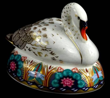 A Royal Crown Derby porcelain paperweight, modelled in the form of a seated swan, silver button to underside, 13cm L.