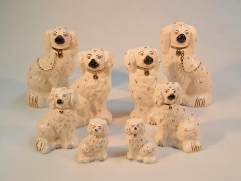 Four pairs of Royal Doulton graduated "Staffordshire" seated comforter dogs