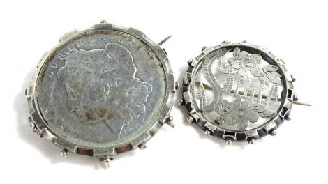 Two silver brooches, being a Victorian Sophia silver brooch, and a United States silver dollar in silver frame, dated 1885, 34.4g all in.