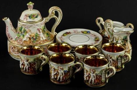 A Capodimonte part coffee service, decorated in relief with putti, flowers, etc., to include teapot and cover, cups, milk jug, etc.