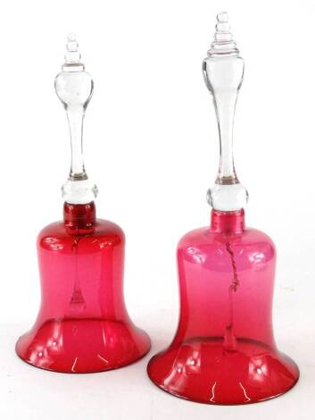 Two similar Victorian glass bells, each with a cranberry tinted bowl, and a turned handle, 35cm and 32.5cm H respectively.