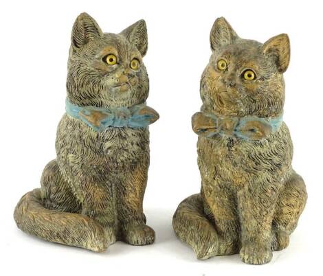 A pair of 19thC cold painted terracotta figures of cats, each wearing a blue bow and with glass eyes, 17cm H.