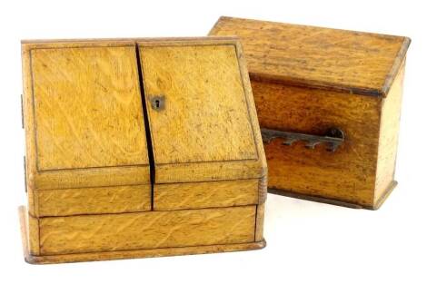 An Edwardian oak stationary box, the hinged sloped top enclosing a fitted interior and another stationary box. (2)