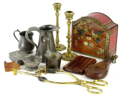 A collection of metalware, to include a pair of brass candlesticks, a Bassett tin containing a calendar, leather and brass shot flask etc.