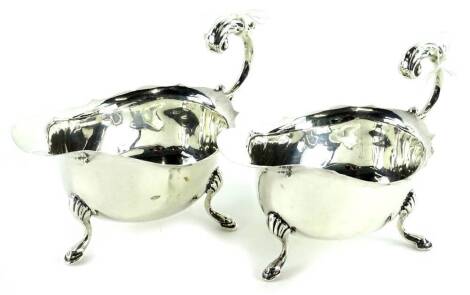 A pair of George VI silver sauce boats, each with a scroll cast handle and shaped legs, Birmingham 1938, 4¾oz.