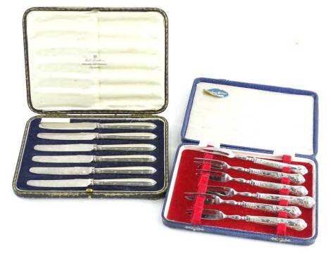 A set of six silver mounted crustacean forks, in a fitted case and a set of six silver handled dessert knives. Auctioneer Announcement: Handles only silver, blades plated.