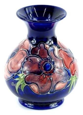 A Moorcroft pottery baluster shaped vase, decorated with a band of poppies on a navy blue ground, impressed marks to underside, 14cm H.