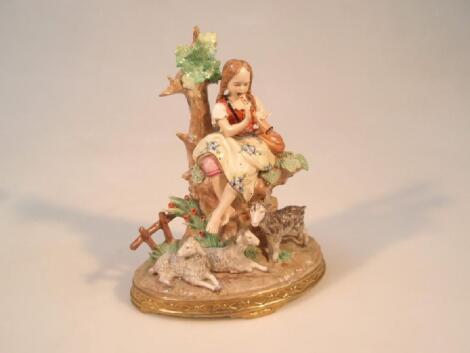 A Sitzendorf porcelain figure group of a young girl seated on a tree stump