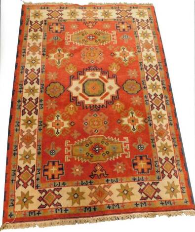 A Persian type rug, with three medallions on a red ground, with multiple borders, 183cm x 123cm.